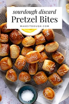 a plate full of pretzel bites with salt and butter on the table next to it