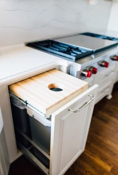 a kitchen with an oven and cutting board in the middle of the counter top area