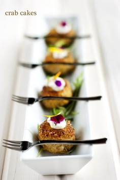 four small white plates with food on them