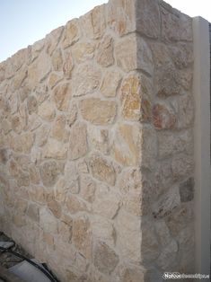 a large stone wall next to a building