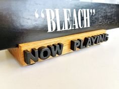 a wooden sign that says bleach'now playing on the side of it