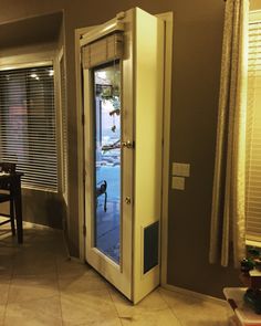 an open door in the middle of a living room next to a table and chairs