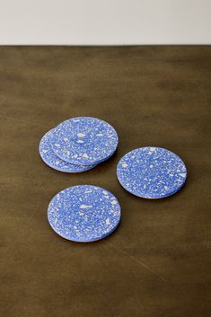 three blue and white plates sitting on top of a brown table next to each other