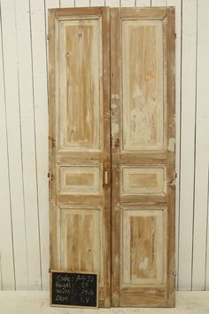 an old wooden door with a chalkboard on it