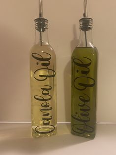 two empty bottles with black lettering sitting next to each other