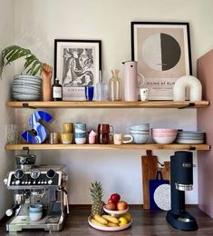 the shelves in this kitchen are filled with different types of dishes and coffee machines, such as pineapples