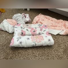 several baby blankets are laying on the floor next to each other and one is folded up