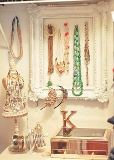 there are many necklaces hanging on the wall in this room, including an antique jewelry box