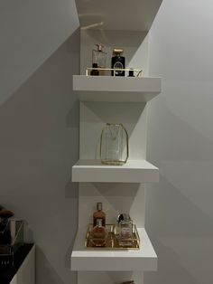 three white shelves with various items on them