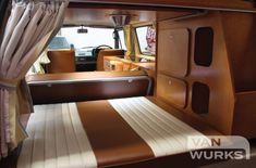 the interior of an rv with tan and white stripes on the floor, windows, and curtains