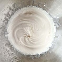 whipped cream in a metal bowl on top of a table