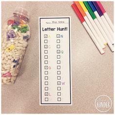 a jar filled with lots of different colored pencils next to a sign that says letter hunt