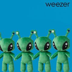 four green alien stuffed animals lined up in a row with the caption weezer