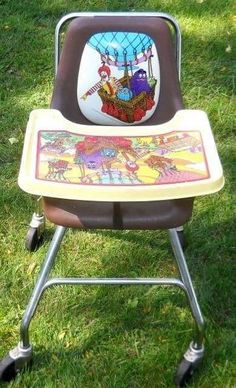 a child's high chair with an animal theme on the back and seat is sitting in the grass