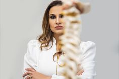 a woman standing with her arms crossed and looking at something in front of her face