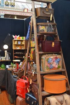 an old ladder is full of suitcases and other items in a store or shop