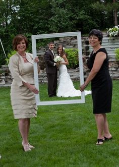 two women standing in front of a mirror with a man and woman looking at it