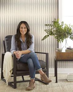 a woman sitting in a chair with her legs crossed and smiling at the camera,