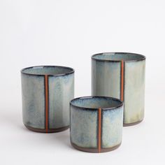 three blue and brown cups sitting next to each other