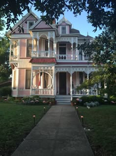 an old victorian house with pink trim and white balconies on the front porch