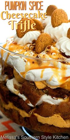 there is a cake with whipped cream and cookies on top in a glass dish that says pumpkin spice cheesecake trifle