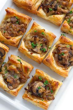 small pastries with mushrooms and parsley on a white platter