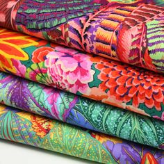 four colorful fabrics stacked on top of each other in different sizes and colors, all featuring flowers