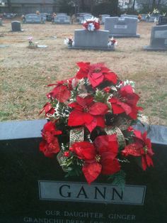 poinsettis are placed on the headstones of many people in this cemetery