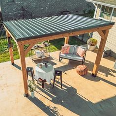 a covered patio area with furniture and an outdoor dining table in the middle of it