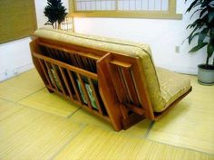 a wooden bench sitting on top of a tile floor next to a potted plant