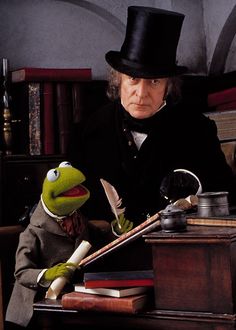 the muppet man and miss piggy are sitting at a desk