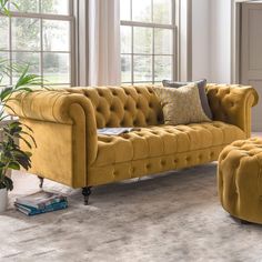 a living room filled with yellow couches and chairs in front of large open windows