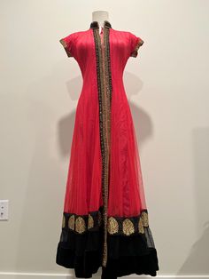 This stunning red Anarkali dress features a dramatic black border adorned with intricate gold embroidery. The flared silhouette and sheer overlay create a timeless and regal look, perfect for weddings, parties, or festive events. Its lightweight fabric ensures comfort while maintaining a sophisticated appearance. Red Anarkali Dress, Black Anarkali Dress, Red Anarkali, Black Anarkali, Sheer Overlay, Gold Embroidery, Anarkali Dress, Black Border, Dress Clothes For Women