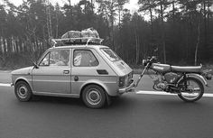 an old car and a motorcycle on the road