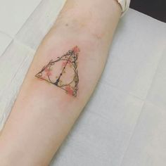 a small triangle tattoo on the arm