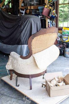 an old chair sitting on top of a wooden platform in a room filled with furniture