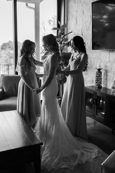 three women in long dresses are standing near each other and talking to each other while the woman is holding her hand out