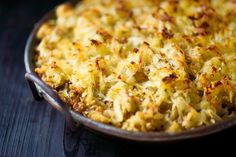 a casserole dish with cheese and other toppings in a pan on a table