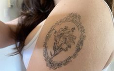 a woman with a flower tattoo on her arm and shoulder is taking a selfie