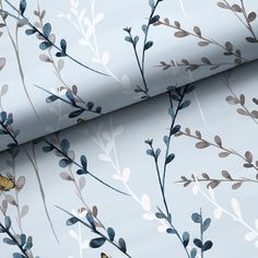 a blue wallpaper with leaves and branches on it