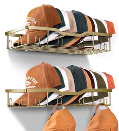 three hats are hanging on two metal racks