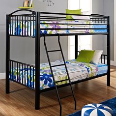 a black bunk bed sitting on top of a hard wood floor next to a window