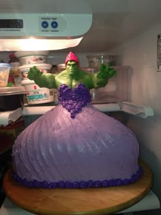 there is a cake in the shape of a princess's dress on top of a refrigerator