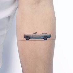 a man's leg with a tattoo of a car on the back of his leg