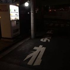 an empty parking lot at night with the light on and no parking sign in front of it