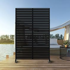 an outdoor deck area with chairs and umbrellas next to the water's edge