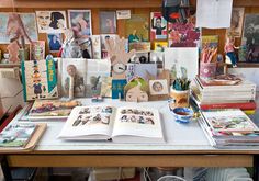 a table with many books and pictures on the top, along with pens and pencils