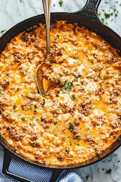 a skillet filled with cheesy ground beef casserole on a marble surface