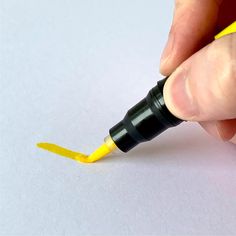 a hand holding a yellow marker and pointing it at the tip of its thumbnail