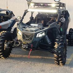 the front end of a four - wheeler parked in a parking lot with its lights on